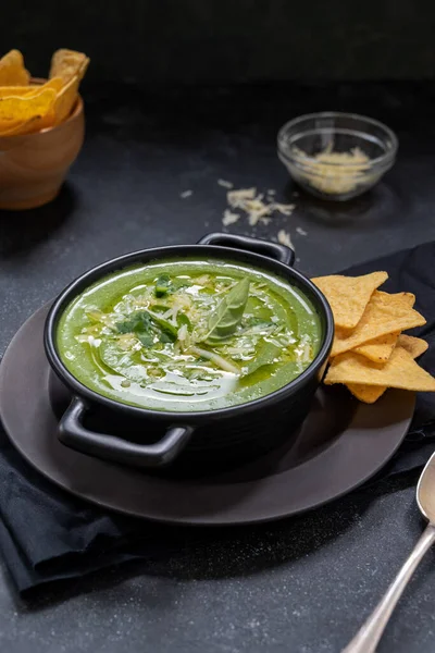 Green creamy soup. Spinach soup in orange bowl. Lifestyle food photo scene, Delicious vegan foods, copy space