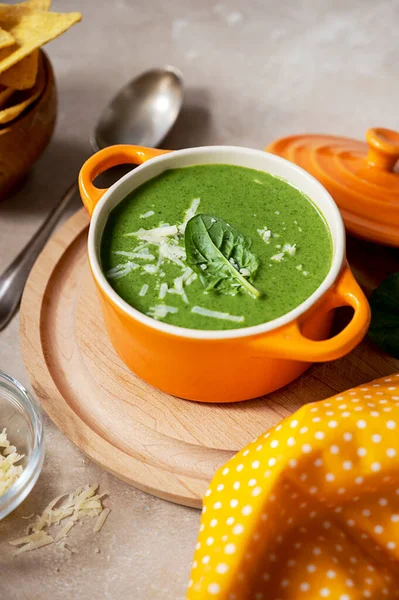 Green creamy soup. Spinach soup in orange bowl. Lifestyle food photo scene, Delicious vegan foods