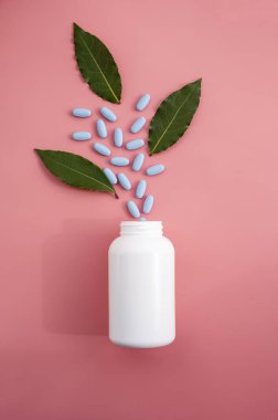 Doğal gıda takviyesi hapları, vitaminli beyaz plastik şişe, pembe arka plan ve gölgeli güneş ışığı.