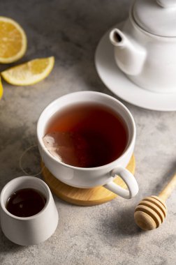 Beyaz seramik bardakta, limon, bal ve nane yapraklı çay. Yaşam tarzı sıcak içecek. Rahatlama kavramı