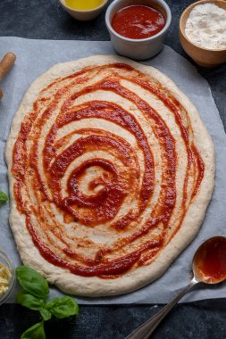 Pizza pişirmek, çiğ hamurda domates sosu. Ev yapımı sourdoguh pizza hamuru, üst manzara..