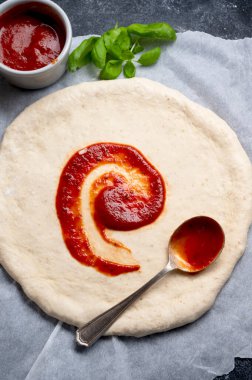 Pizza pişirmek, çiğ hamurda domates sosu. Ev yapımı sourdoguh pizza hamuru, üst manzara..