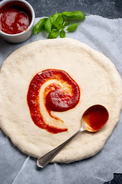 Pizza pişirmek, çiğ hamurda domates sosu. Ev yapımı sourdoguh pizza hamuru, üst manzara..