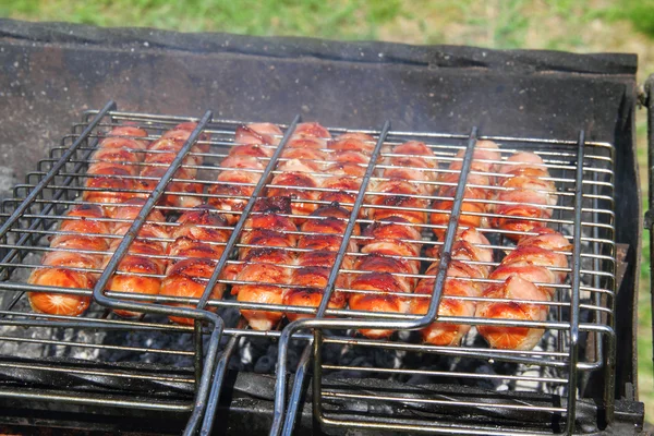 Saucisses fraîches grillées à l'extérieur sur un gril — Photo