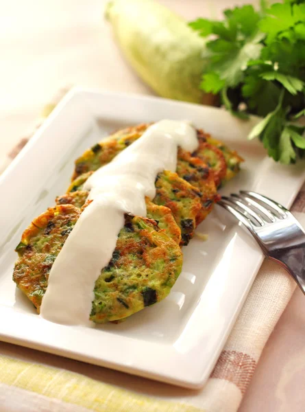 Zucchini pancakes with green onions and sour cream — Stock Photo, Image
