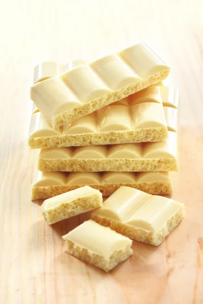 White porous chocolate on wooden background — Stock Photo, Image