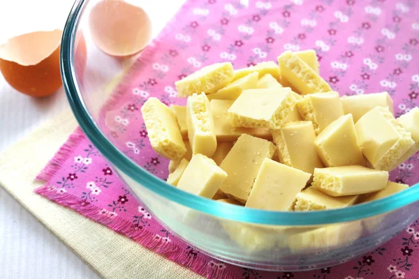 Bar of white chocolate broken into pieces in a glass bowl — Stock Photo, Image