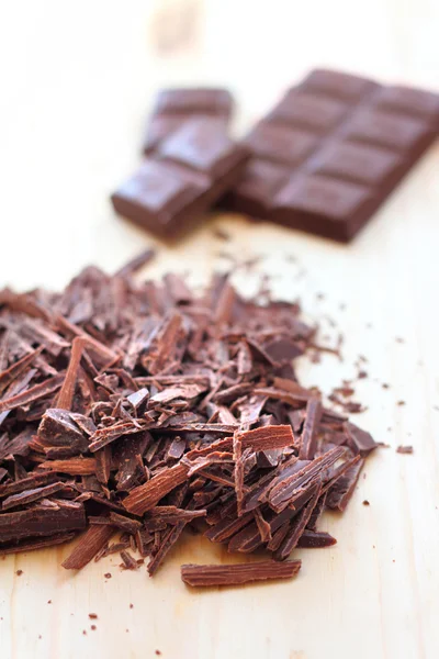 Ahşap zemin üzerine koyu çikolata kıyılmış bar — Stok fotoğraf