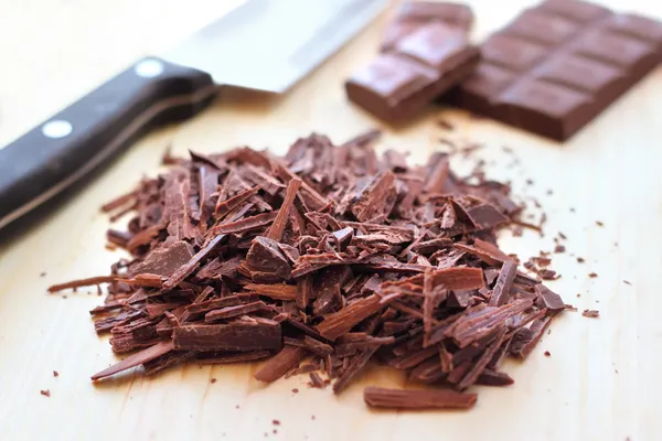 Ahşap zemin üzerine koyu çikolata kıyılmış bar — Stok fotoğraf