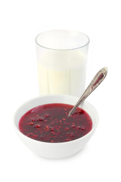 Glass of milk and a bowl of raspberry confiture — Stock Photo, Image