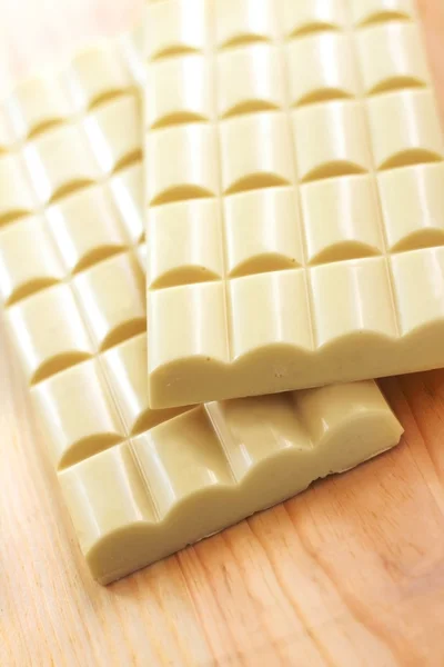 Bars of white porous chocolate on wooden background — Stock Photo, Image