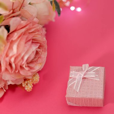 Kurdeleli, romantik arkaplanlı küçük açık pembe bir kutu. Sürpriz şefkat konsepti