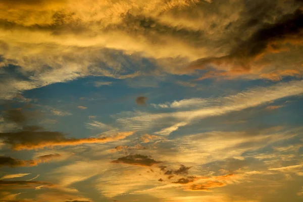 Sunset clouded sky in yellow, orange and blue colors