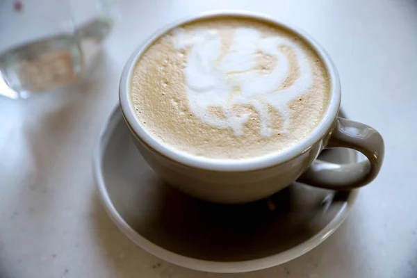 A mug of cappuccino for breakfast in a street cafe