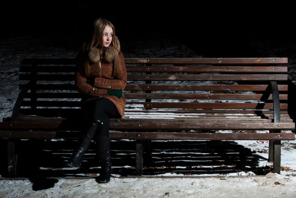 Charming girl in expectation on a bench — Stock Photo, Image