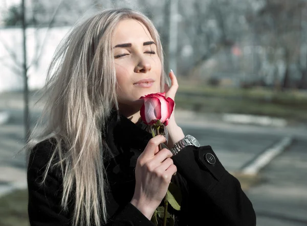 Menina feliz bonita com rosa vermelha na mão — Fotografia de Stock