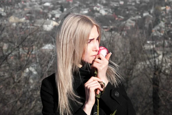 Beautiful thoughtful girl with red rose in hand — Stock Photo, Image