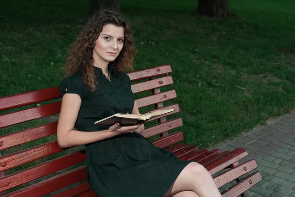 Belle jeune fille en soirée lecture livre en plein air — Photo