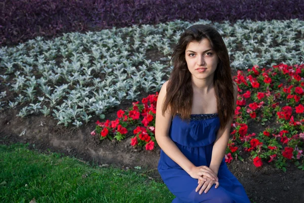 Krásná orientální dívka sedící v květech — Stock fotografie