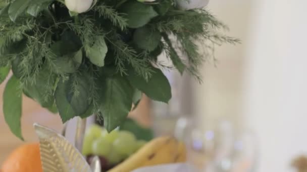Esküvői csokor fehér rózsát és a zöld levelek az asztalon — Stock videók