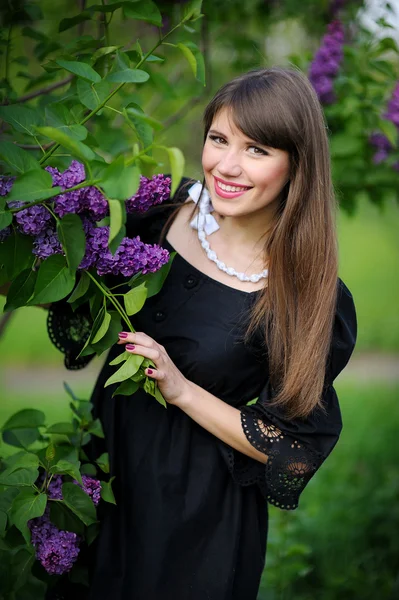 Meisje met lila in het park — Stockfoto