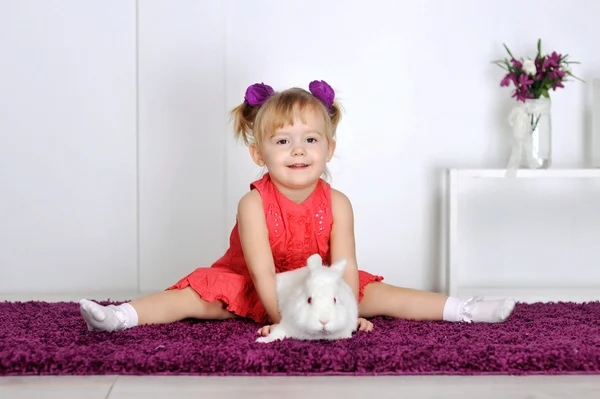 Улыбающаяся маленькая девочка и белый кролик — стоковое фото
