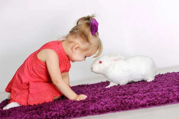 Niña sonriente y conejo blanco — Foto de Stock