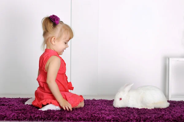 Lächelndes kleines Mädchen und weißes Kaninchen — Stockfoto