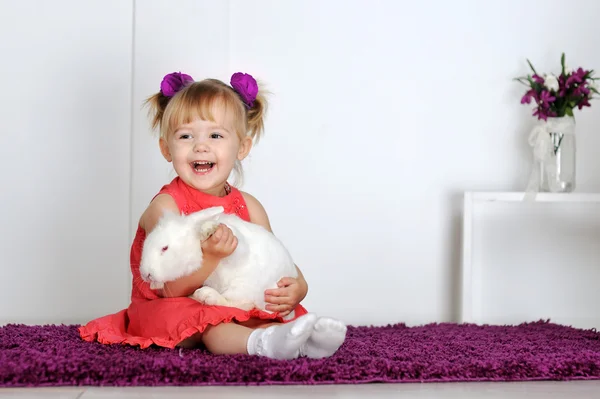 Улыбающаяся маленькая девочка и белый кролик — стоковое фото