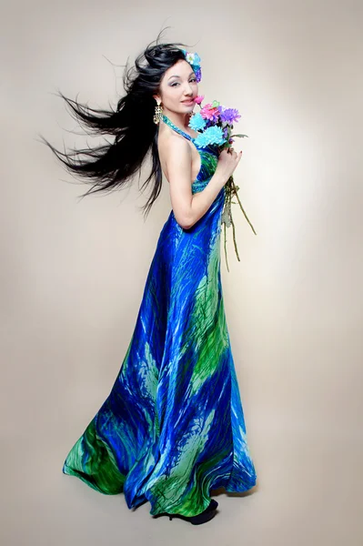 Mooie jonge vrouw met kleurrijke bloemen in haar — Stockfoto