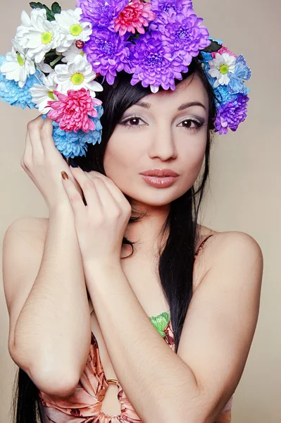 Beautiful young woman with colorful flowers in hair — Stock Photo, Image
