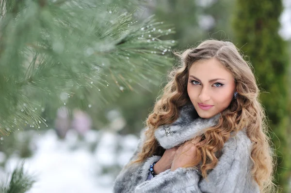 Frau im Pelzmantel im Winterpark — Stockfoto
