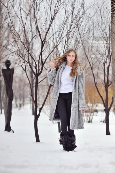 Frau im Pelzmantel im Winterpark — Stockfoto