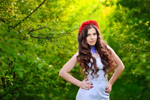 Jovem bela mulher em grinalda floral em fundo natural — Fotografia de Stock