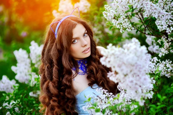 Menina bonita com uma flor lilás o sol — Fotografia de Stock