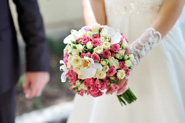 Bruiloft boeket in handen van de bruid — Stockfoto