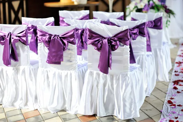 The chairs are decorated with purple bows — Stock Photo, Image