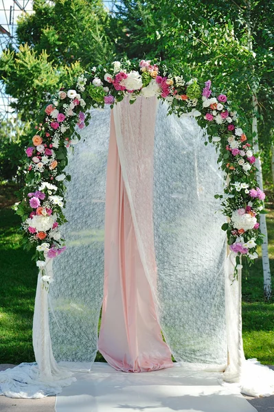 Arco de casamento com flores na grama — Fotografia de Stock