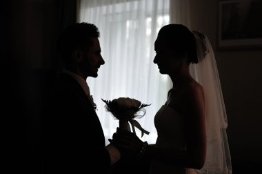 silhouette of a bride and groom in front of the window