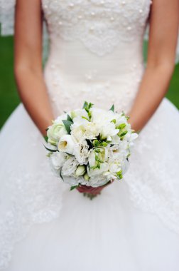 Gelin elleri güzel bir düğün buketi tutuyor.