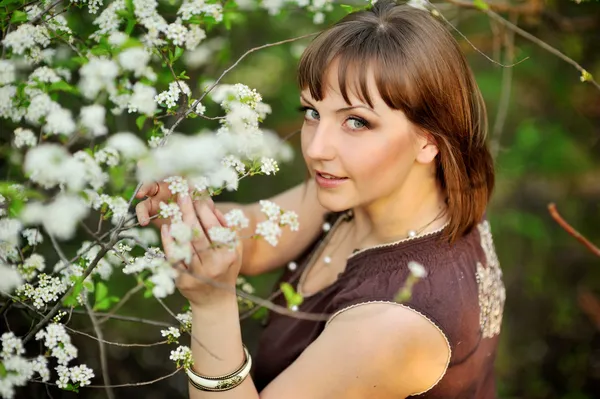 Vacker flicka på naturen nära blommande träd — Stockfoto