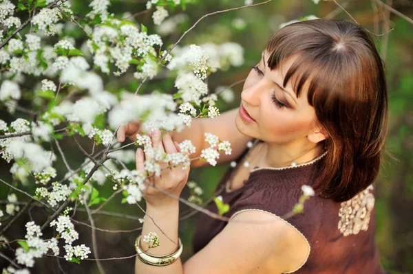 Menina bonita na natureza perto de árvores floridas — Fotografia de Stock