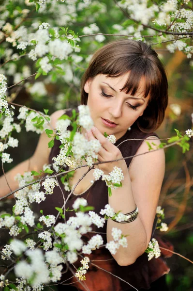 Menina bonita na natureza perto de árvores floridas — Fotografia de Stock