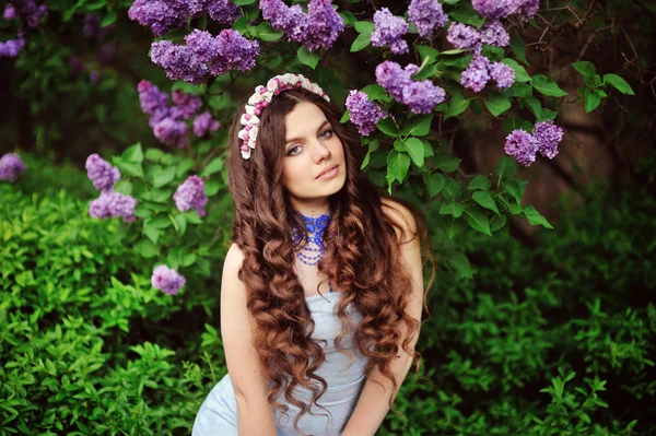 Schöne junge Frau in fliederfarbenen Blumen, im Freien Porträt — Stockfoto