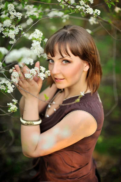 Beautiful young brunette woman standing near tree — Stock Photo, Image