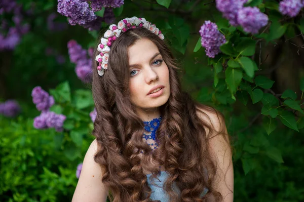 Beautiful girl with a flower lilac — Stock Photo, Image