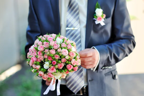 Marié tient un bouquet de mariage — Photo