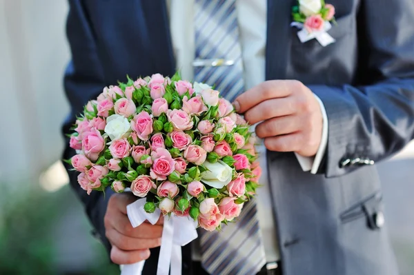 Bräutigam hält Brautstrauß in der Hand — Stockfoto
