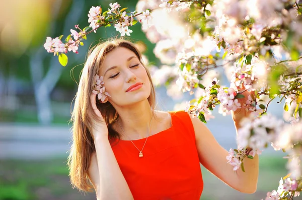 Красивая женщина с белым цветущим деревом — стоковое фото