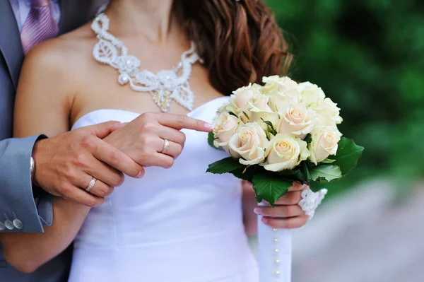 Groom and bride holding hands with wedding rings — Stock Photo, Image